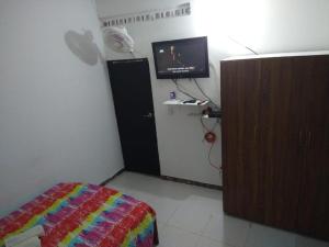 una camera con letto, TV e armadio di Casa acogedora Girardot 150mts a Girardot