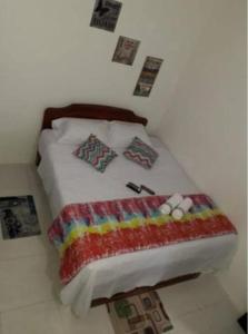 un letto con coperta colorata e cuscini sopra di Casa acogedora Girardot 150mts a Girardot