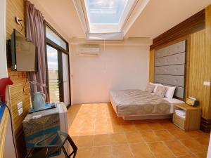 una piccola camera con letto e lucernario di Big Fish Homestay a Magong