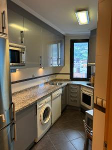 a kitchen with a washer and dryer in it at Apartamento Oviedo Naranco in Oviedo