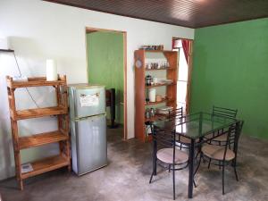a kitchen with a glass table and a refrigerator at Casa el Colibrí in Naranjo +20 photos