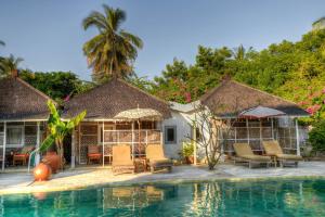 a resort with a pool and chairs and trees at Les Villas Ottalia Gili Meno in Gili Meno