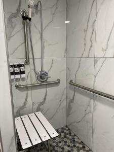 a shower with a bench in a bathroom at Sea Garden Inn Pismo Beach- San Luis Obispo in Pismo Beach
