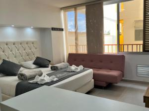 una sala de estar con una cama y un sofá en Aptos y Apartaestudios frente al Malecón y el Embalse, Zona Gastronómica, a 8 minutos de la Piedra del Peñol, TODO CERCA!!!, en Guatapé