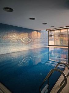a large swimming pool with a painting on the wall at Taksim Perfect Residence, 3 bedrooms, pool, sauna, gym in Istanbul