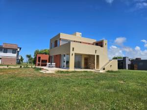 a house on top of a grass field at Prados del Mar PB in San Clemente del Tuyú