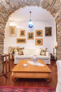 a living room with white couches and a table at Gladiolus House - Tinos in Tzádhos
