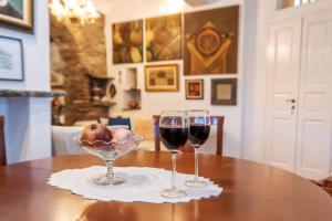 two glasses of wine sitting on a table at Gladiolus House - Tinos in Tzádhos