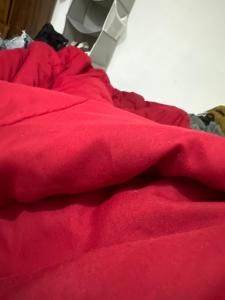 a red blanket sitting on top of a bed at guest house panorama GJirokaster in Gjirokastër