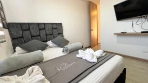 Un dormitorio con una cama con toallas. en Aptos y Apartaestudios frente al Malecón y el Embalse, Zona Gastronómica, a 8 minutos de la Piedra del Peñol, TODO CERCA!!!, en Guatapé 16 fotos más