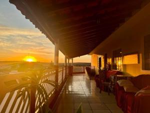 a balcony with a view of the ocean at sunset at Pousada B&B - na cidade Capivari-SP in Capivari