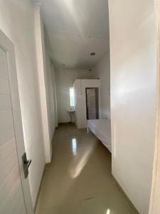 an empty room with a bed and a white door at kamar kos in Delitua