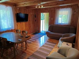 a living room with a table and a couch at Domek nad Pisą in Kolno