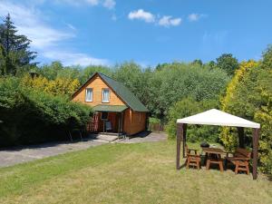 a house with a picnic table and a tent at Domek nad Pisą in Kolno