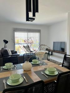 a dining room table with green dishes on it at AG Apartment in Trelew