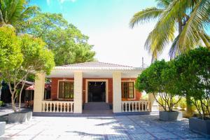 a house with a palm tree in front of it at JKAB Park Hotel in Trincomalee