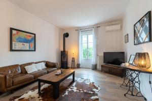 a living room with a couch and a tv at Villa de Charme Climatisée avec Piscine au Centre in Gardanne