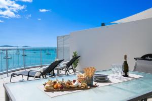 Una mesa con un plato de comida en un balcón. en Penthouse Oasis On Airlie, en Airlie Beach 18 fotos más