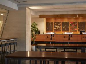 a restaurant with tables and chairs and paintings on the wall at Hotel Villa Fontaine Tokyo-Ueno Okachimachi in Tokyo