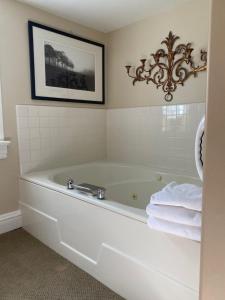 a white bath tub in a bathroom with a picture at Inn at Occidental in Occidental