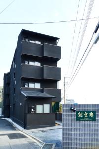 a black building with a sign in front of it at Rikyuan Kyoto Nishikyogoku in Kyoto