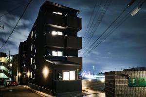 a black building at night with lights on at Rikyuan Kyoto Nishikyogoku in Kyoto
