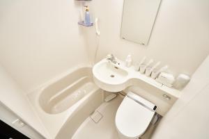a bathroom with a sink and a toilet and a mirror at Rikyuan Kyoto Nishikyogoku in Kyoto