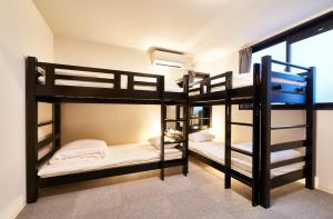 a room with three bunk beds and a window at Rikyuan Kyoto Nishikyogoku in Kyoto