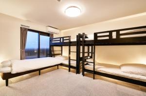 two bunk beds in a room with a window at Rikyuan Kyoto Nishikyogoku in Kyoto