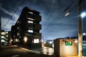 a black building on a city street at night at Rikyuan Kyoto Nishikyogoku in Kyoto