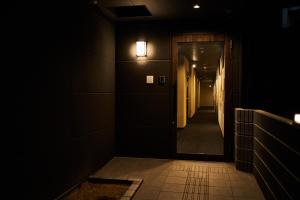 a dark hallway with a door and a light at Rikyuan Kyoto Nishikyogoku in Kyoto