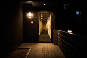 a dark hallway with two lights on the wall at Rikyuan Kyoto Nishikyogoku in Kyoto