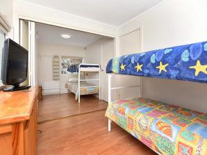 a bedroom with a bunk bed and a flat screen tv at Boomer Waves 5 Carfax St - WIFI included - No Linen Included in Port Elliot