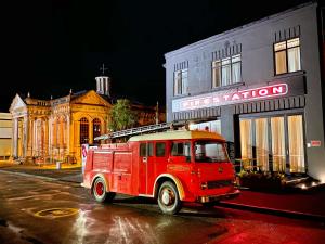 an old red fire truck parked in front of a building at Hokitika Fire Station Boutique Accommodation in Hokitika
