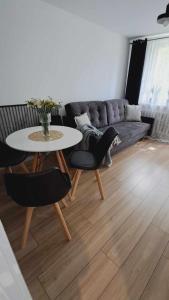 a living room with a table and a couch at APARTAMENT FLOWERS - KIELCE in Kielce +16 photos