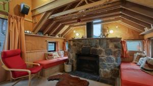 a living room with a fireplace and a red chair at Pinnacle in Dinner Plain