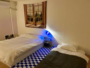 a bedroom with a bed and a window with a blue light at Momo House2 in Gimhae