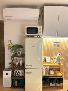 a refrigerator with a microwave on top of it at Momo House2 in Gimhae