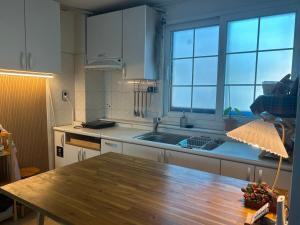 a kitchen with a wooden table and a sink at Momo House2 in Gimhae
