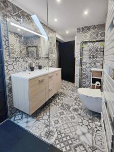 a bathroom with a tub and a toilet and a sink at Appartement Le Baroque en duplex in Mulhouse +55 photos