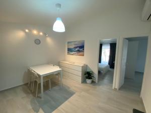 a white room with a desk and a table at Apartmani Gršćica 2 in Blato +9 photos