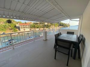 a balcony with a table and chairs and a view of the ocean at Apartmani Gršćica 2 in Blato