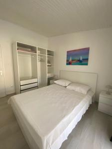 a white bedroom with a large white bed in it at Apartmani Gršćica 2 in Blato