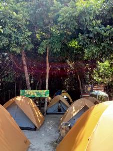 a group of tents in a field with trees at Redang Campstay in Redang Island