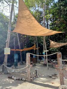 a tent in the middle of a field with trees at Redang Campstay in Redang Island