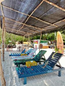 a group of blue lounge chairs under a straw umbrella at Redang Campstay in Redang Island