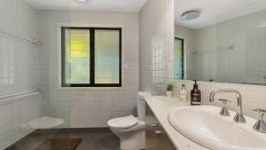 ein weißes Badezimmer mit Waschbecken und Toilette in der Unterkunft Opal Oasis in Pearl Beach