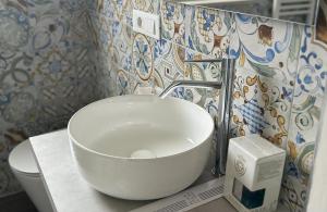 a bathroom with a bowl sink and a toilet at Casa MarFe in Grottaglie