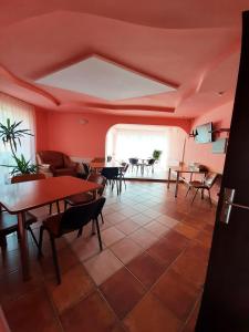 a room with tables and chairs and a large window at Pensiunea Sanlex in Bicaz
