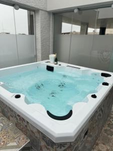 a jacuzzi tub with blue water in a bathroom at Casa MarFe in Grottaglie